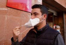 Una persona se quita la mascarilla al salir de un centro de Salud