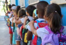 Archivo - Varios niños hacen fila con sus mochilas en una imagen de archivo