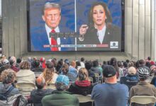 Decenas de personas siguen el debate entre Donald Trump y Kamala Harris en una pantalla gigante en San Francisco.