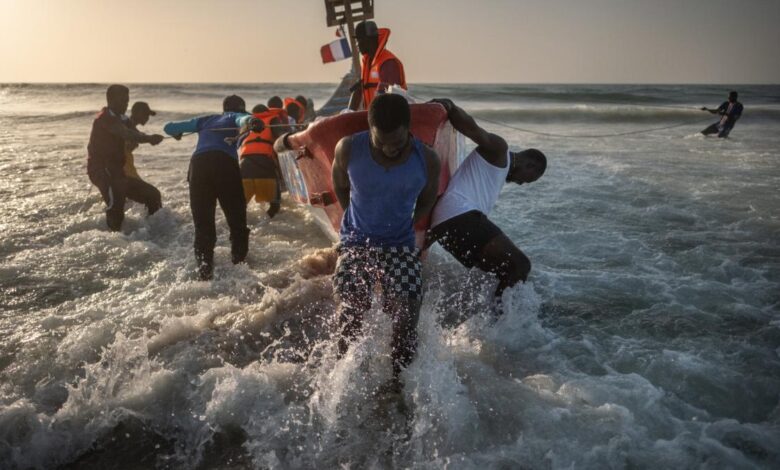 Un grupo de pescadores entran en el mar con un cayuco en el barrio de Guet N’Dar, en Saint Louis, Senegal