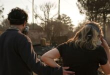 Una pareja observa el paisaje desolado tras el incendio.