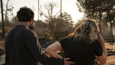 Una pareja observa el paisaje desolado tras el incendio.